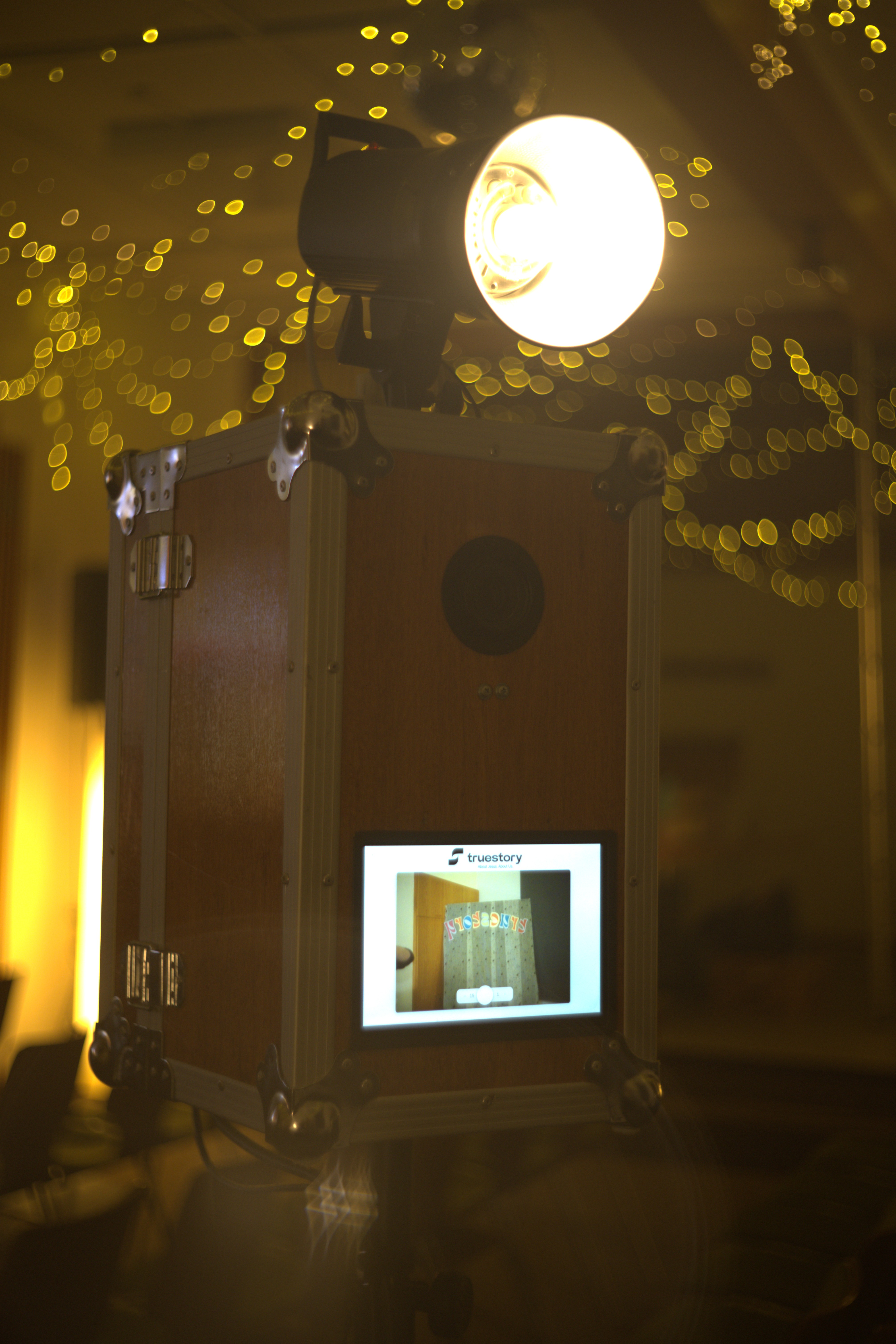 Fotobox aus Holz mit warmer Lichterkette auf einer Feier – Fotobox für die Hochzeit mieten